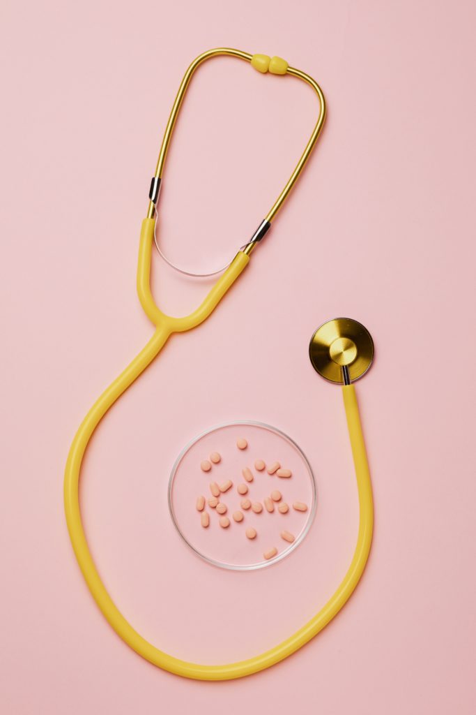yellow stethoscope and pills on pink background 4047073